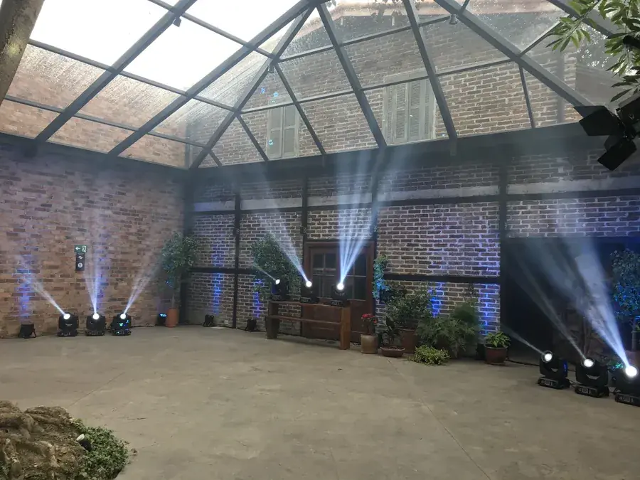 Iluminação cênica com moving heads em estrutura de galpão